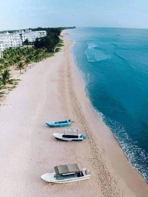 Srilankan beach view, blue water and white sand next to a hotel