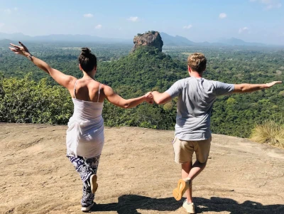 some guests holding hands on Pidurangala Rock facing Sigiriya rock