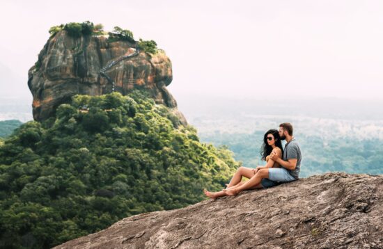 A couple in love on a rock admires the beautiful views. Boy and girl on the rock